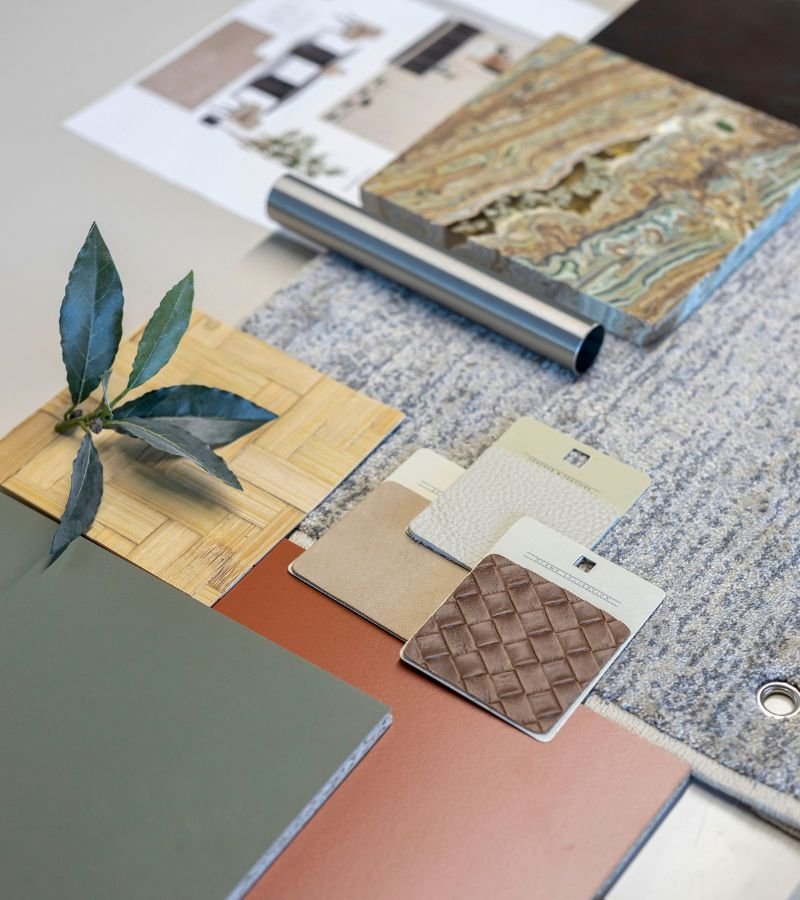 Moodboard de design de interiores com amostras de mármore, pele entrelaçada, tecidos e paleta de tons terra, refletindo o cuidado técnico aplicado em serviços de decoração e soluções de interior design de luxo.
