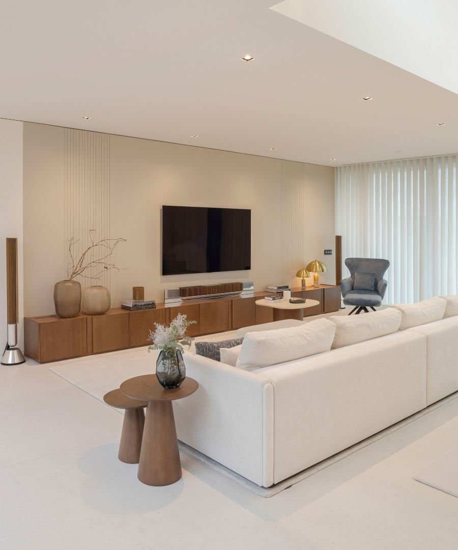 Sala de estar sofisticada e luminosa com mobiliário contemporâneo e tons neutros, resultado final de projetos de interior design e completos serviços de design de interiores pensados para casas modernas e casas de luxo.