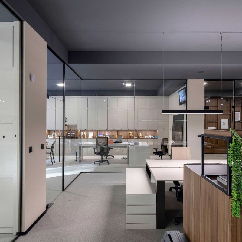 Projeto de design de interiores para um open office corporativo, que reflete um serviço de design de interiores focado em funcionalidade e no moderno interior design de escritórios, com divisórias de vidro e postos de trabalho integrados.