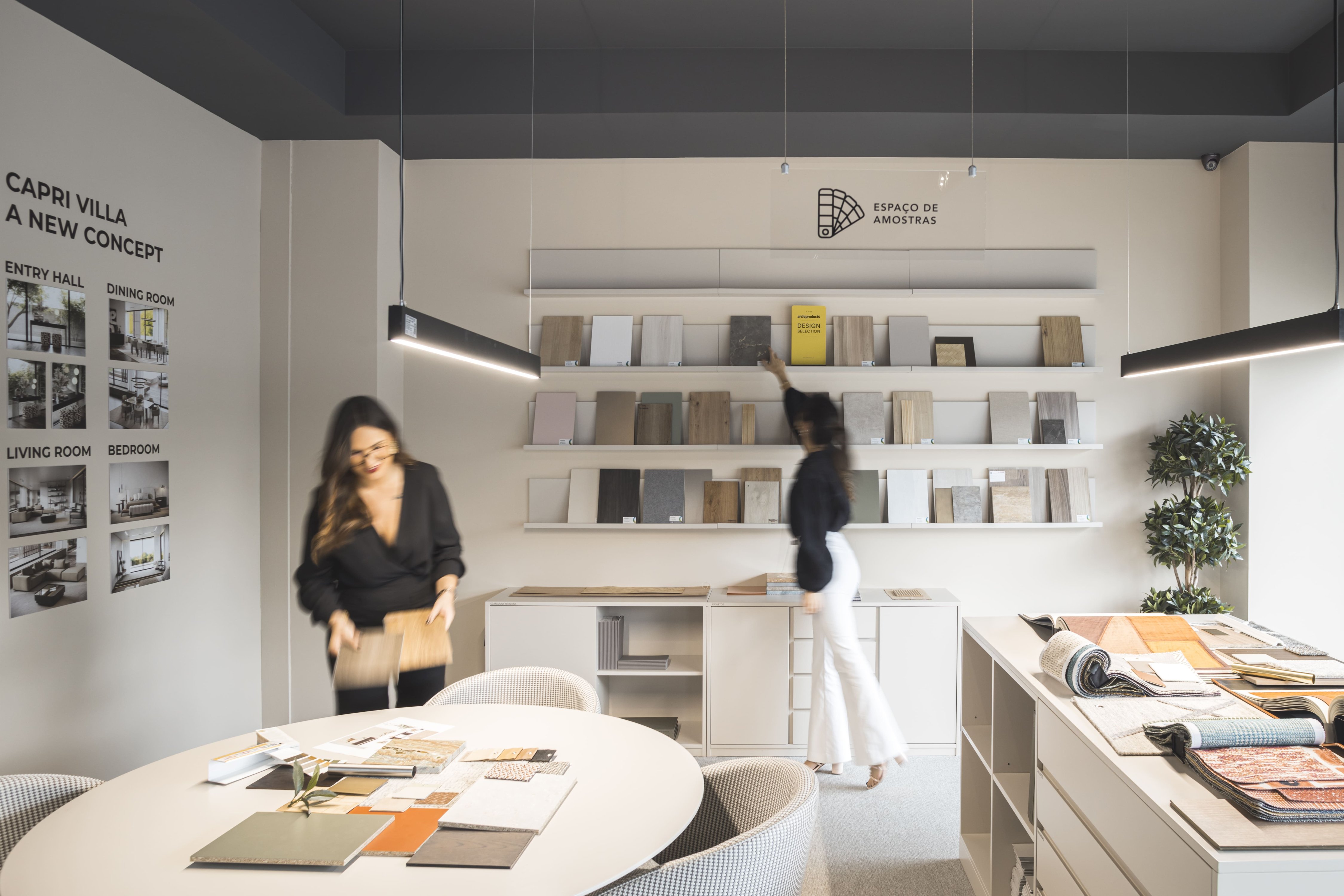 Designers no espaço de amostras a selecionar materiais e acabamentos para casas modernas, demonstrando a excelência dos serviços de design de interiores, soluções de decoração à medida e conceitos inovadores de interior design.