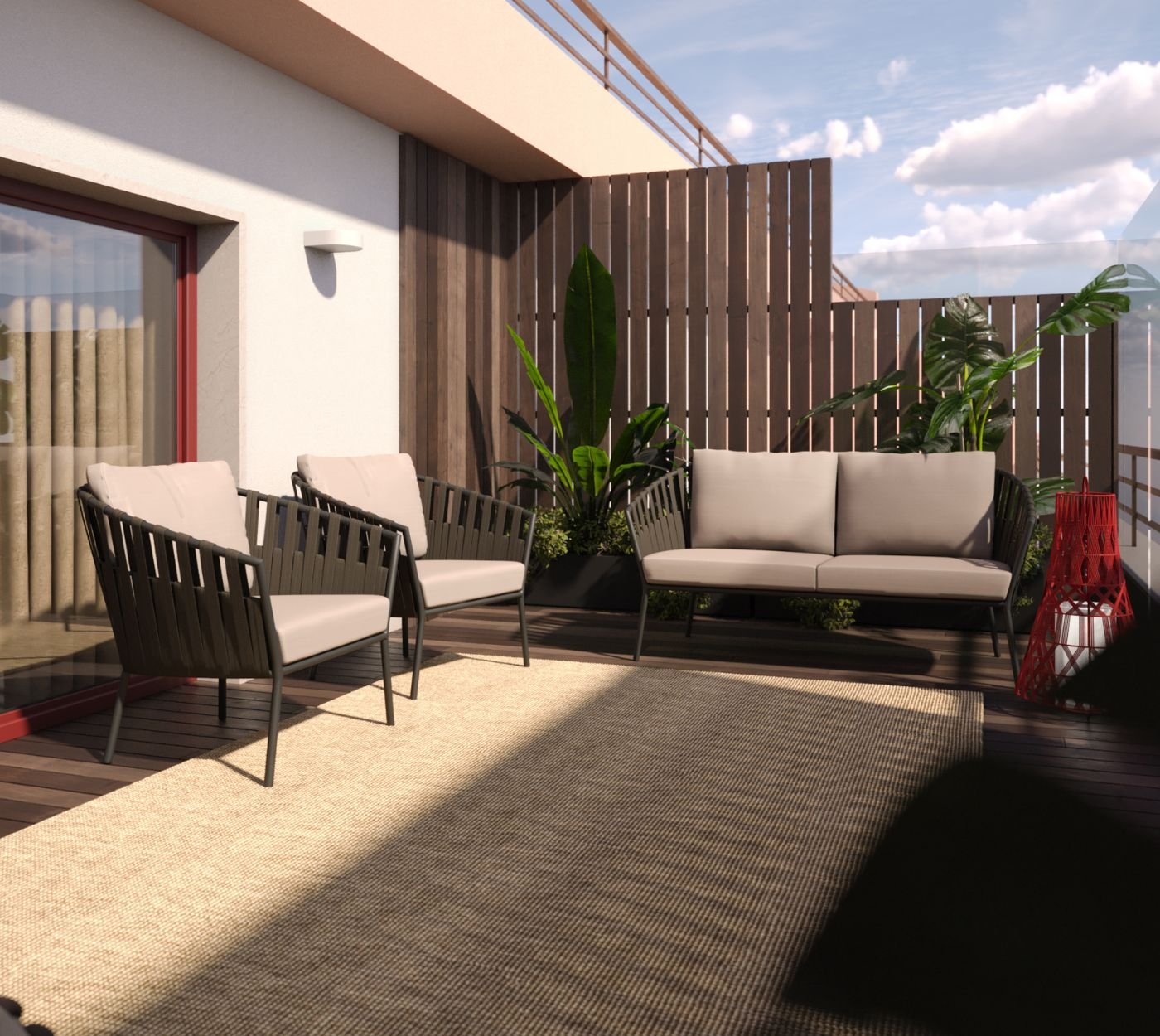 Vista lateral de um canto relaxante numa varanda de design, com três puffes de mobiliário de exterior com padrão geométrico verde em cima de um grande tapete circular de fibras. A área de mobiliário de exterior está organizada sobre um deck de madeira escura na varanda, com duas pequenas mesas laterais pretas e uma lanterna vermelha vibrante como decoração de varanda. Paredes terracota e um parapeito de madeira criam a moldura da varanda, que também apresenta plantas tropicais como decoração de jardins exteriores. A decoração de varanda com o mobiliário de exterior confortável e a lanterna vermelha criam um ambiente acolhedor. O parapeito da varanda oferece uma vista para a paisagem. Este mobiliário de exterior e a decoração de jardins exteriores na varanda são ideais para o lazer.
