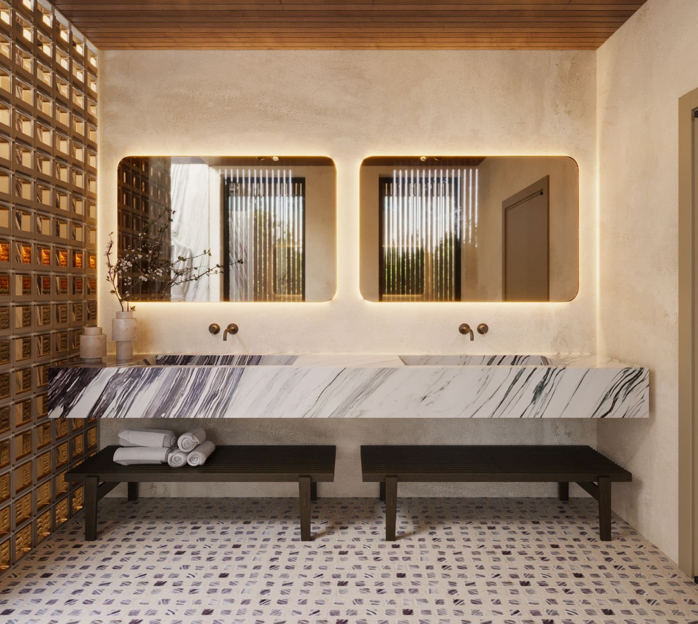Bancada dupla de mármore com espelhos retroiluminados e bancos de apoio, exemplificando a harmonia entre os móveis de casa de banho e o design de interiores deste espaço moderno.