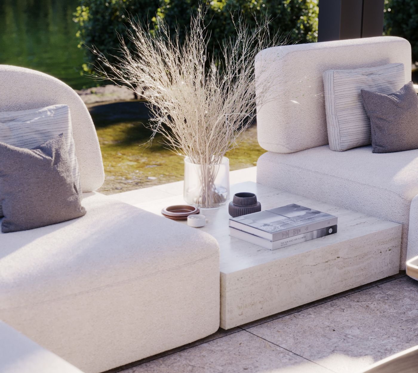Pormenor de mesas de centro em travertino com jarro decorativo entre módulos de sofá modular, aliando o mobiliário de jardim ao requinte da decoração sala e do design de interiores.