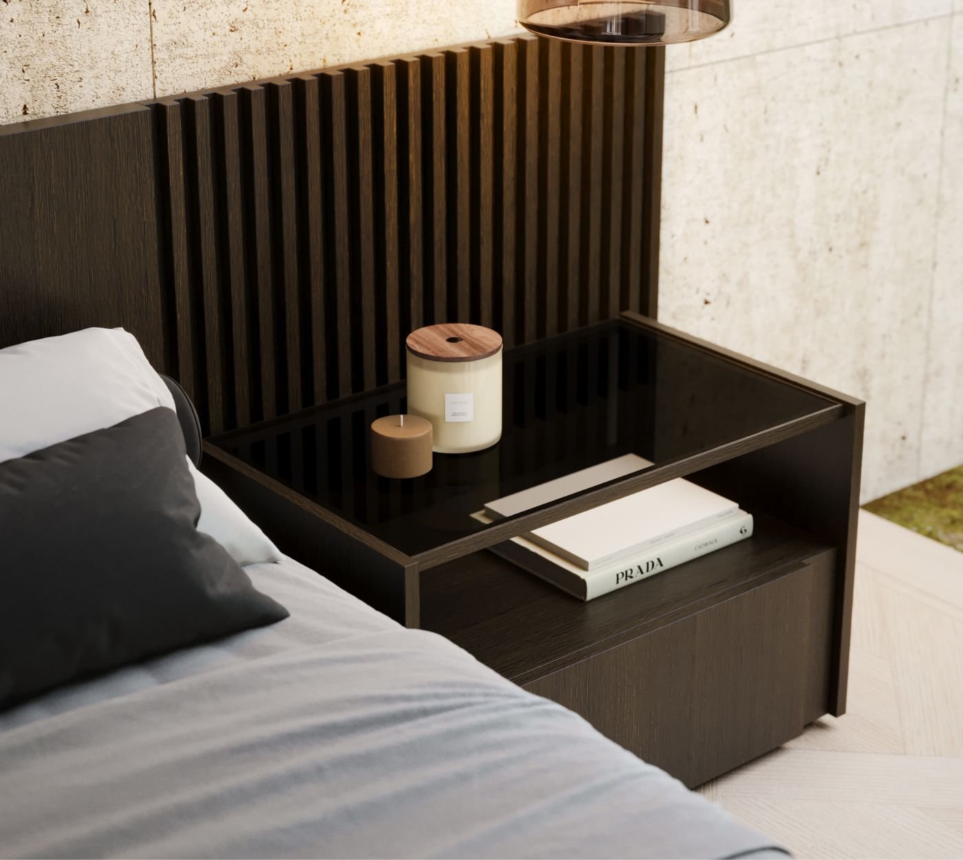 Detalhe de mesa de cabeceira suspensa em madeira escura com vela e livro da Prada, ao lado de cama. Design de interiores na decoração de quarto de casal.