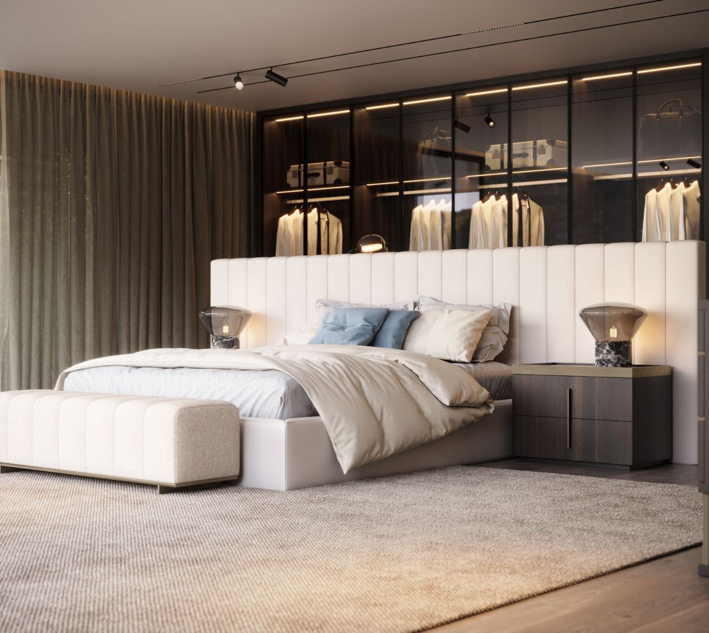 Cama de casal com banco aos pés, closet em vidro iluminado ao fundo e mesa de cabeceira moderna num elegante quarto de casal.