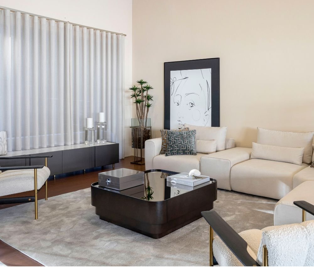 Sala contemporânea em tons neutros com sofá modular e mesa de centro escura, reunindo ideias de decoração e a excelência de um serviço de luxo e serviço de design de interiores em interior design para casas de luxo.