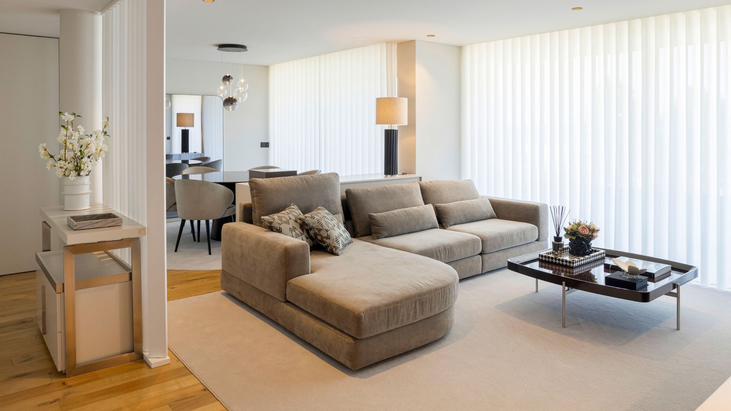Vista aproximada de um acolhedor sofa chaise longue com almofadas e mesa de centro elegante, valorizando a decoração sala nesta luminosa sala de estar em open space.