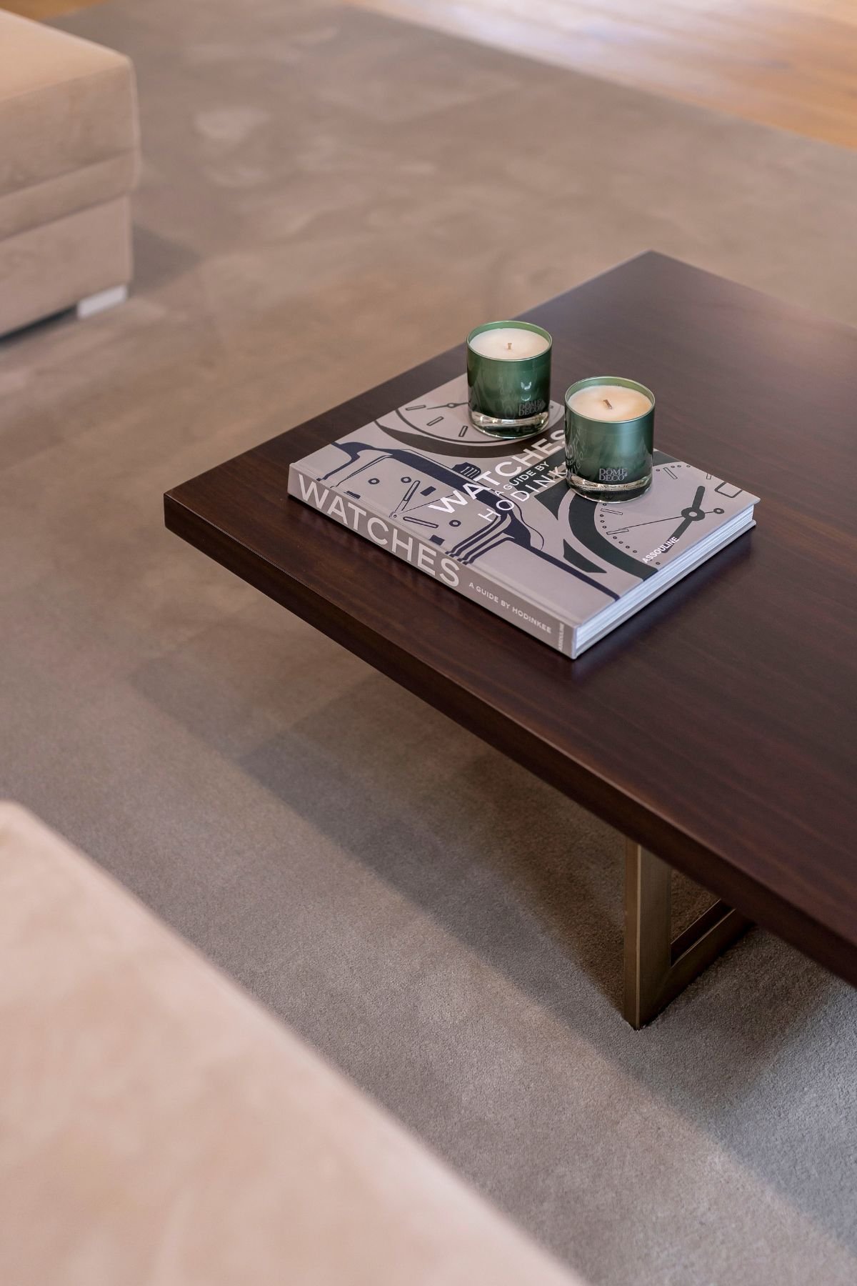 Close de mesa de centro com velas perfumadas e livro de arte em open space sereno, destacando os detalhes táteis de interior design e decoração em casas de luxo.