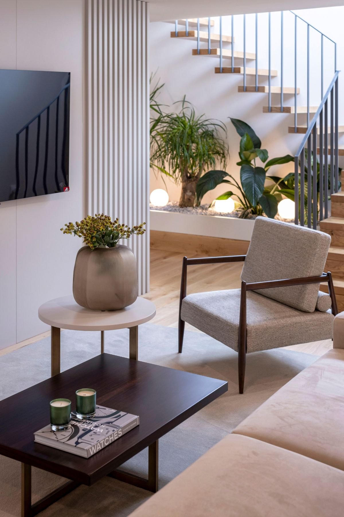 Poltrona contemporânea e mesa de centro com jarras em open space acolhedor, expressando a harmonia entre interior design e sublime decoração em casas de luxo.