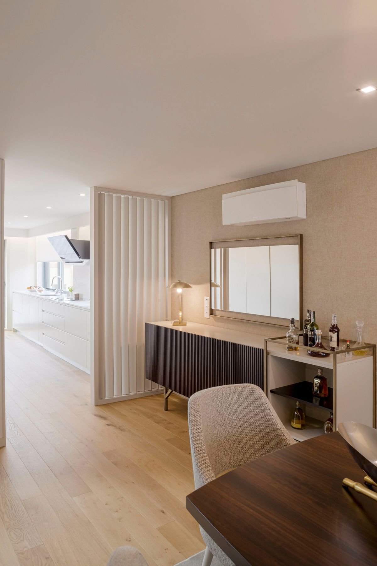 Aparador com garrafeira e espelho em sala de jantar elegante, junto a mesa para sala de jantar e cadeira de sala de jantar de interior design.