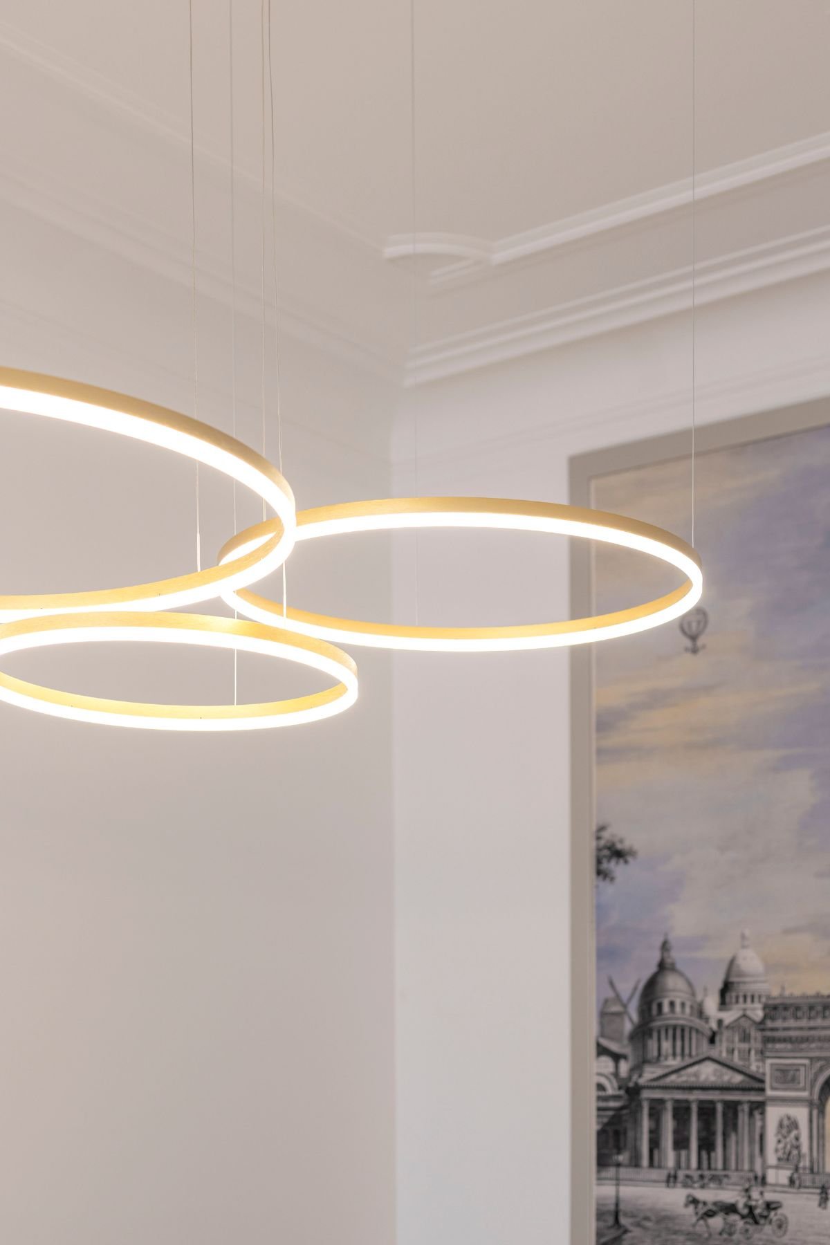 Pormenor de candeeiros de teto suspensos em formato circular LED, ideais para elevar a iluminação e decoração num projeto de interiores moderno.