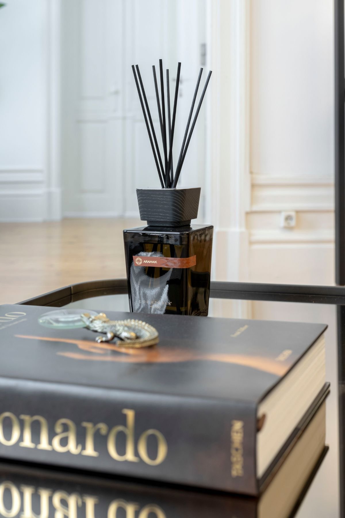 Difusor de aroma sobre livro de arte numa mesa de centro, perfeito para a decoração e bem estar do espaço.