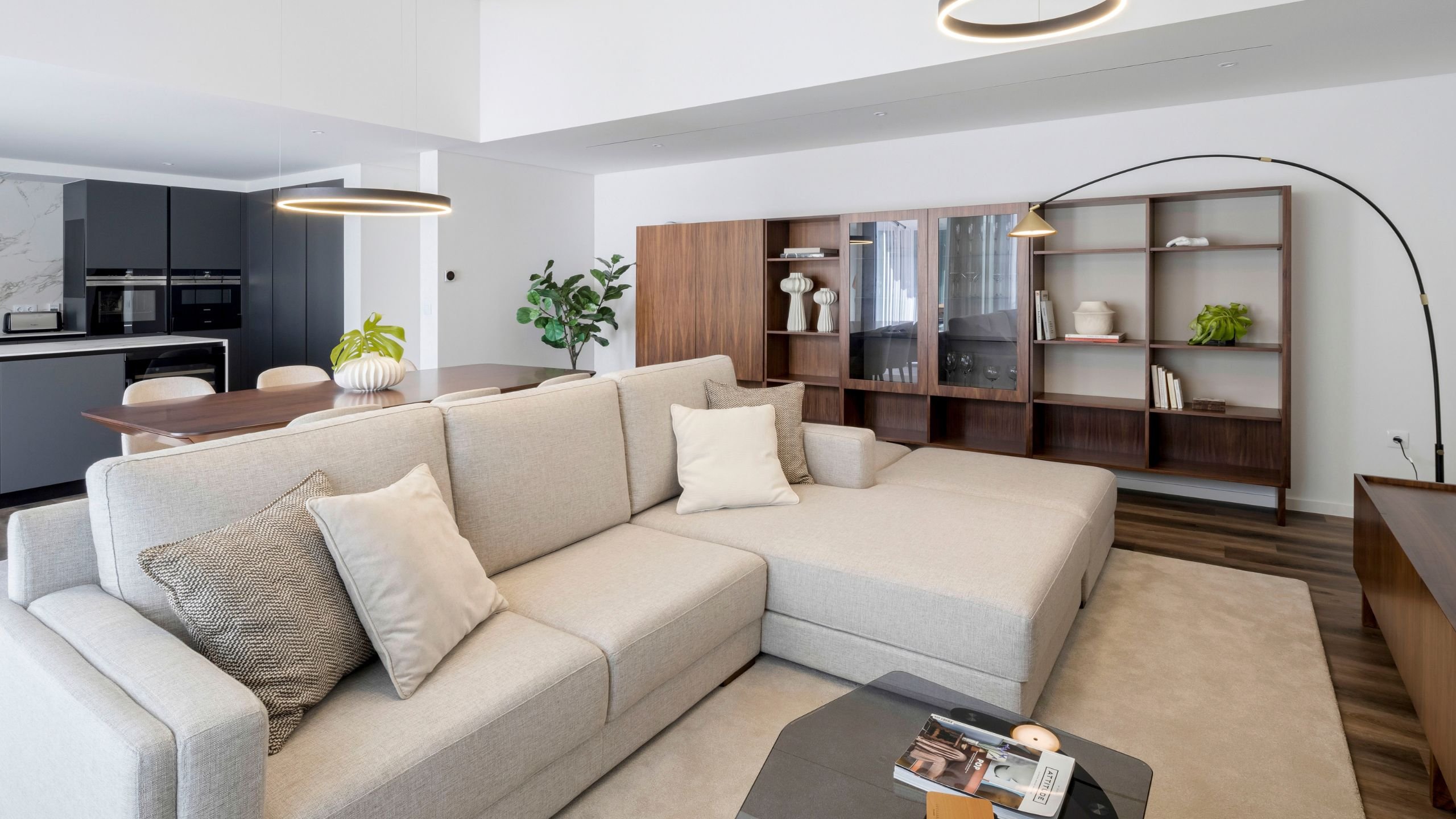 Sala de estar de inspiração nórdica com sofá chaiselongue em tecido bege e móvel de tv em nogueira natural.
