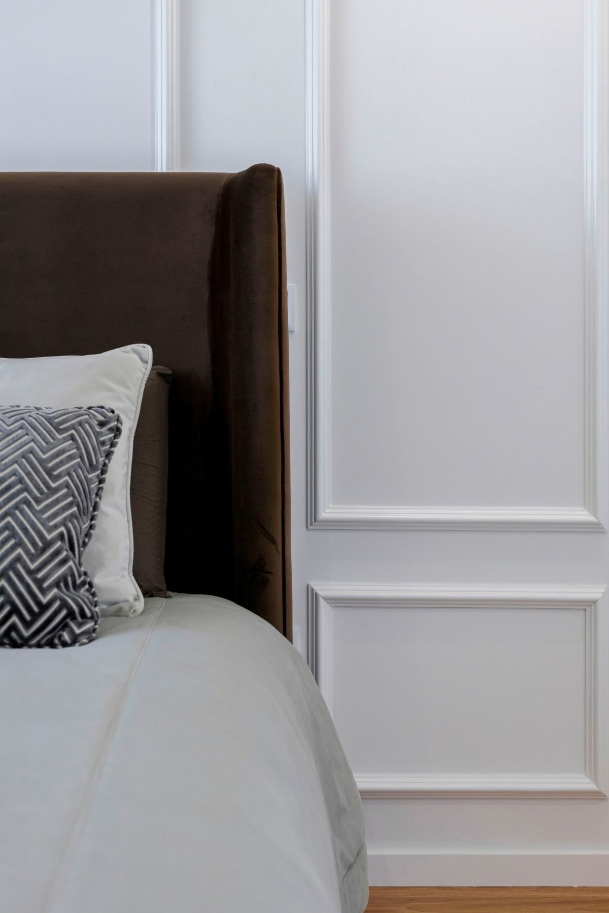 Visão em ângulo amplo do quarto de hóspedes, mostrando o conjunto completo da cama preparada, a luz ambiente de canto e a atmosfera serena do espaço.