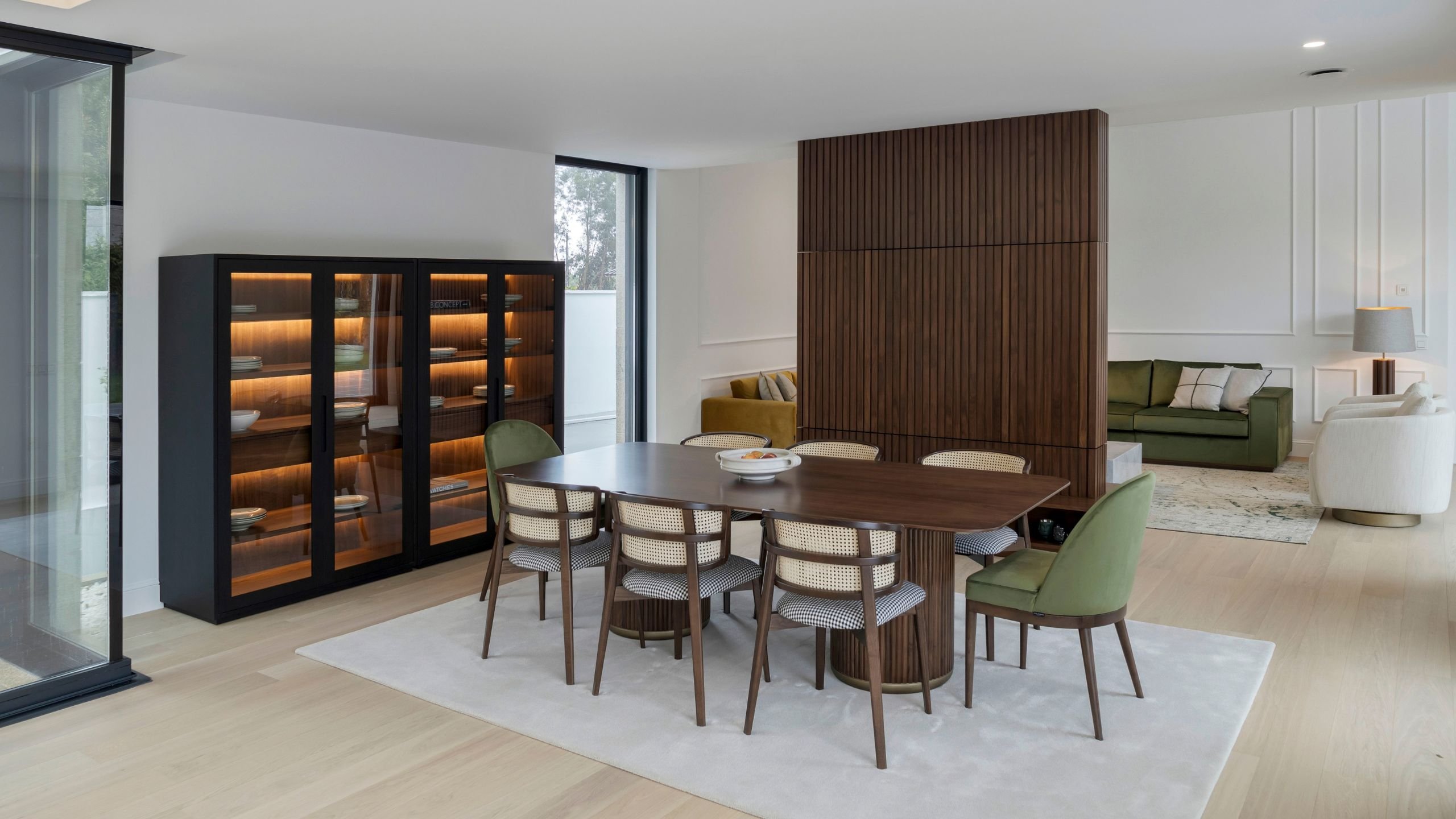 Espaço amplo com mesa para sala de jantar em madeira e cadeira sala de jantar estofada, definindo uma sofisticada sala de jantar em conceito open space.