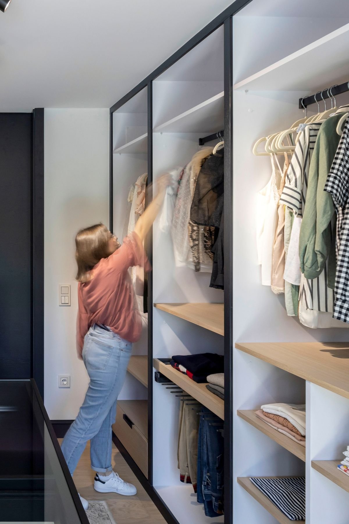 Organização de vestuário em prateleiras e varões de closet aberto, refletindo a excelência do design de interiores num walk-in closet dream closet.