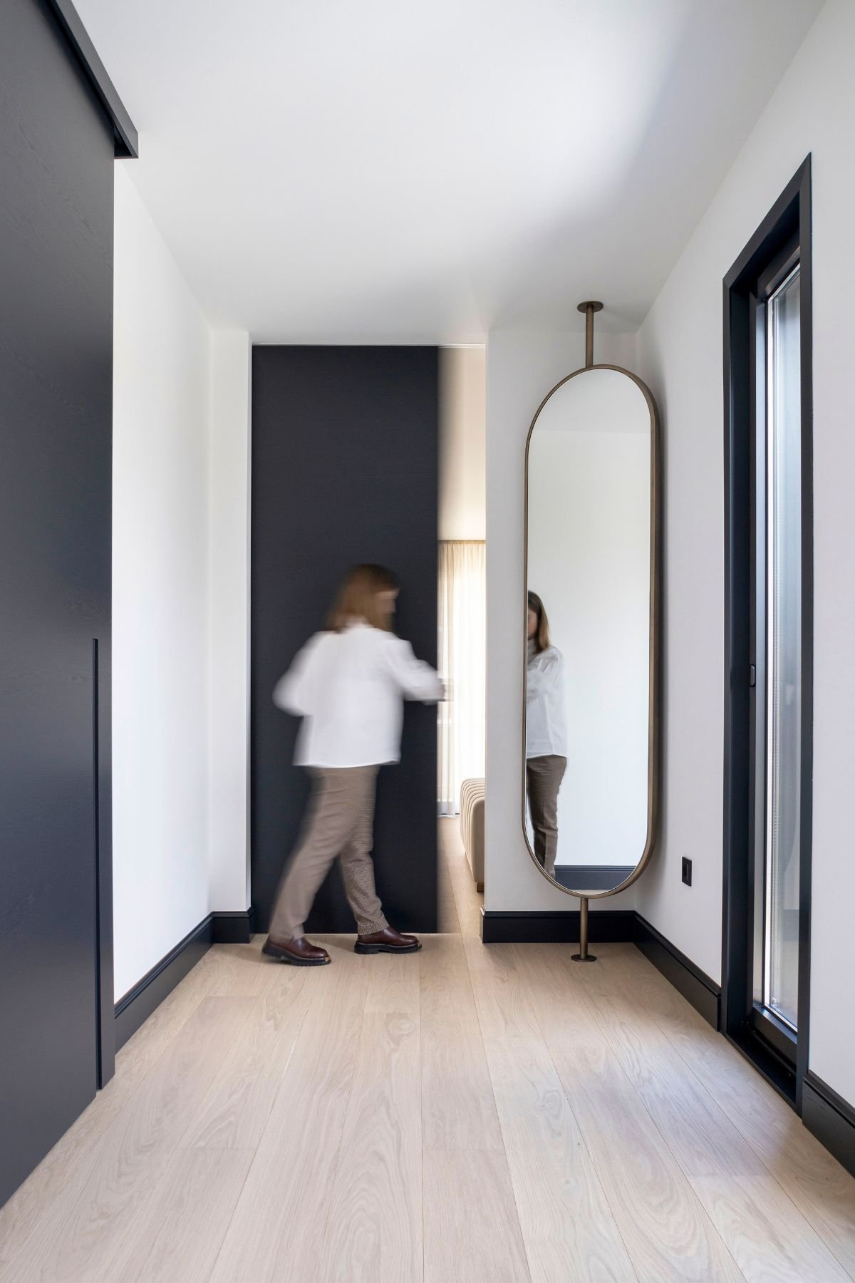 Espelho giratório de corpo inteiro em corredor de acesso ao walk-in closet, demonstrando o design de interiores que liga ao closet aberto e dream closet.