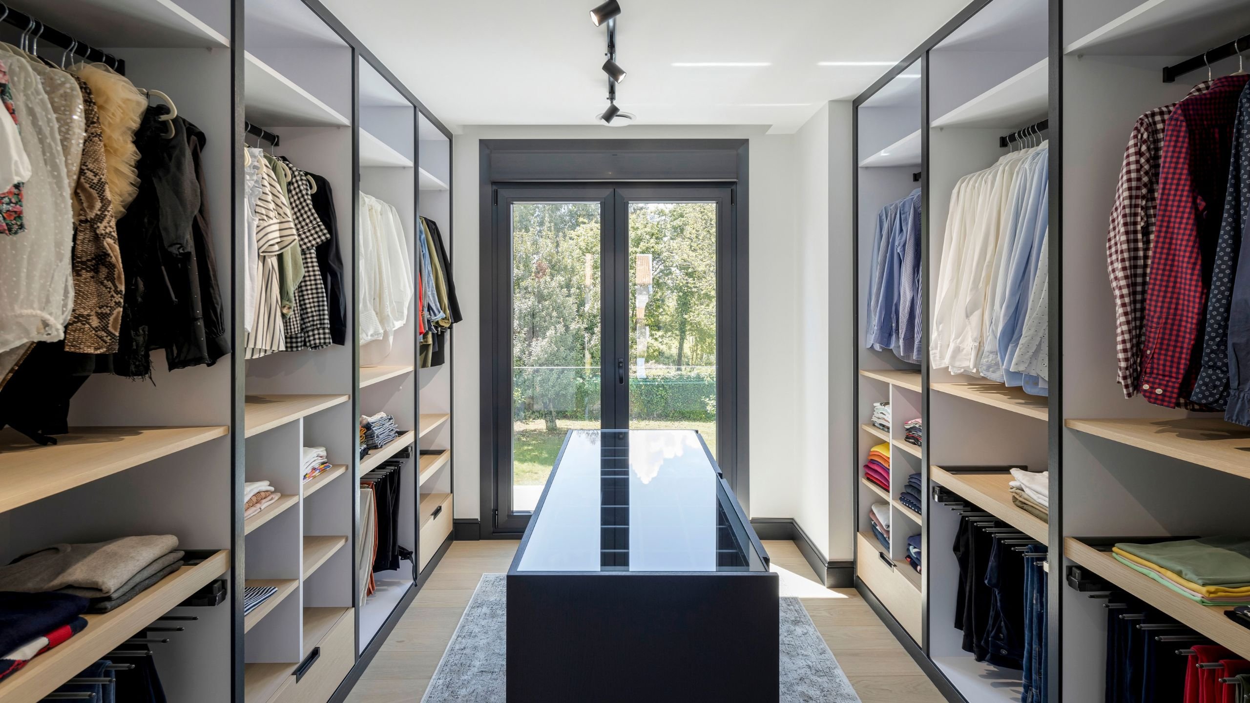 Espaçoso walk-in closet com ilha central e armários organizados, um autêntico dream closet em closet aberto com sofisticado design de interiores.
