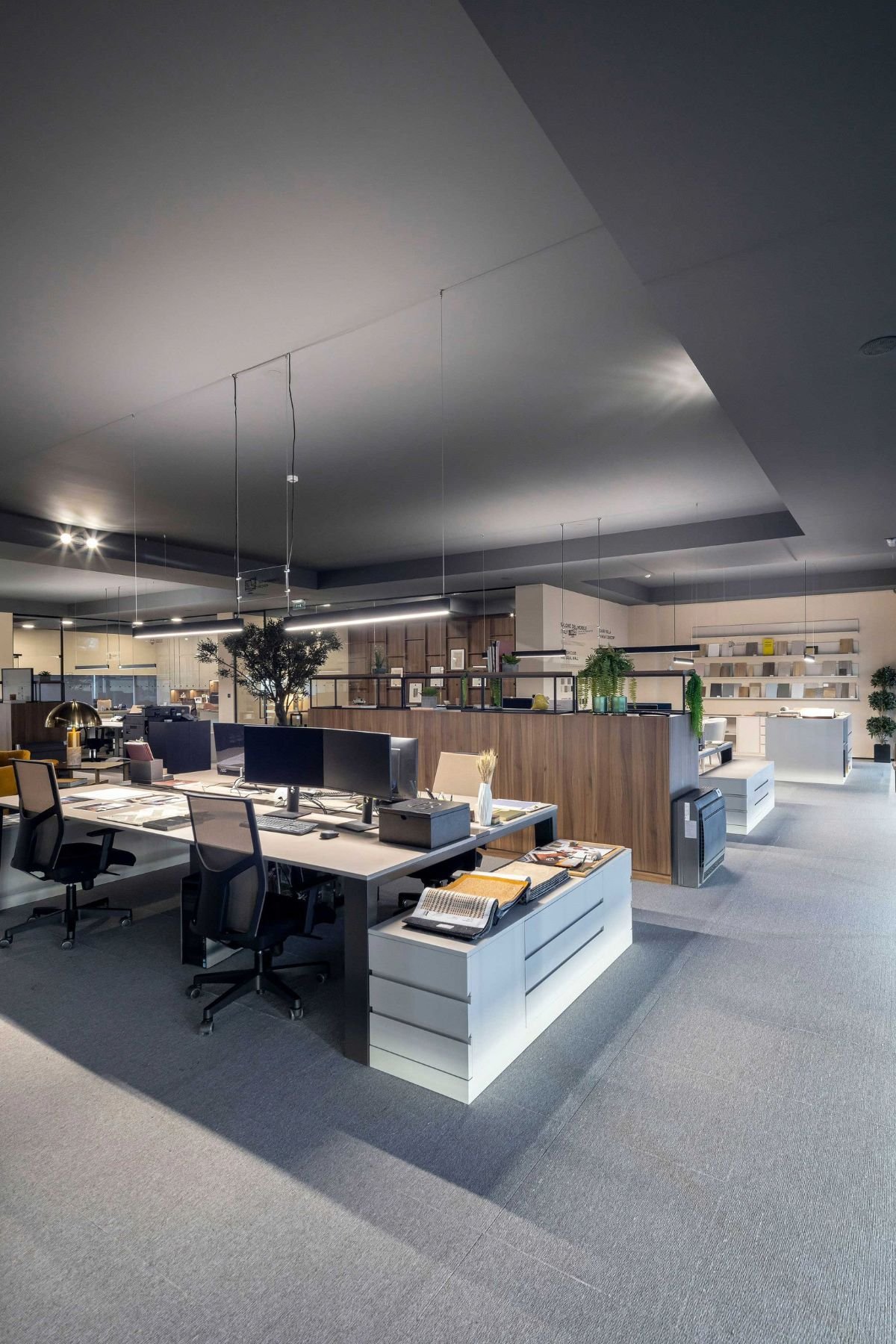Espaço de trabalho partilhado com secretária de escritório equipada e cadeira de escritório ergonómica.