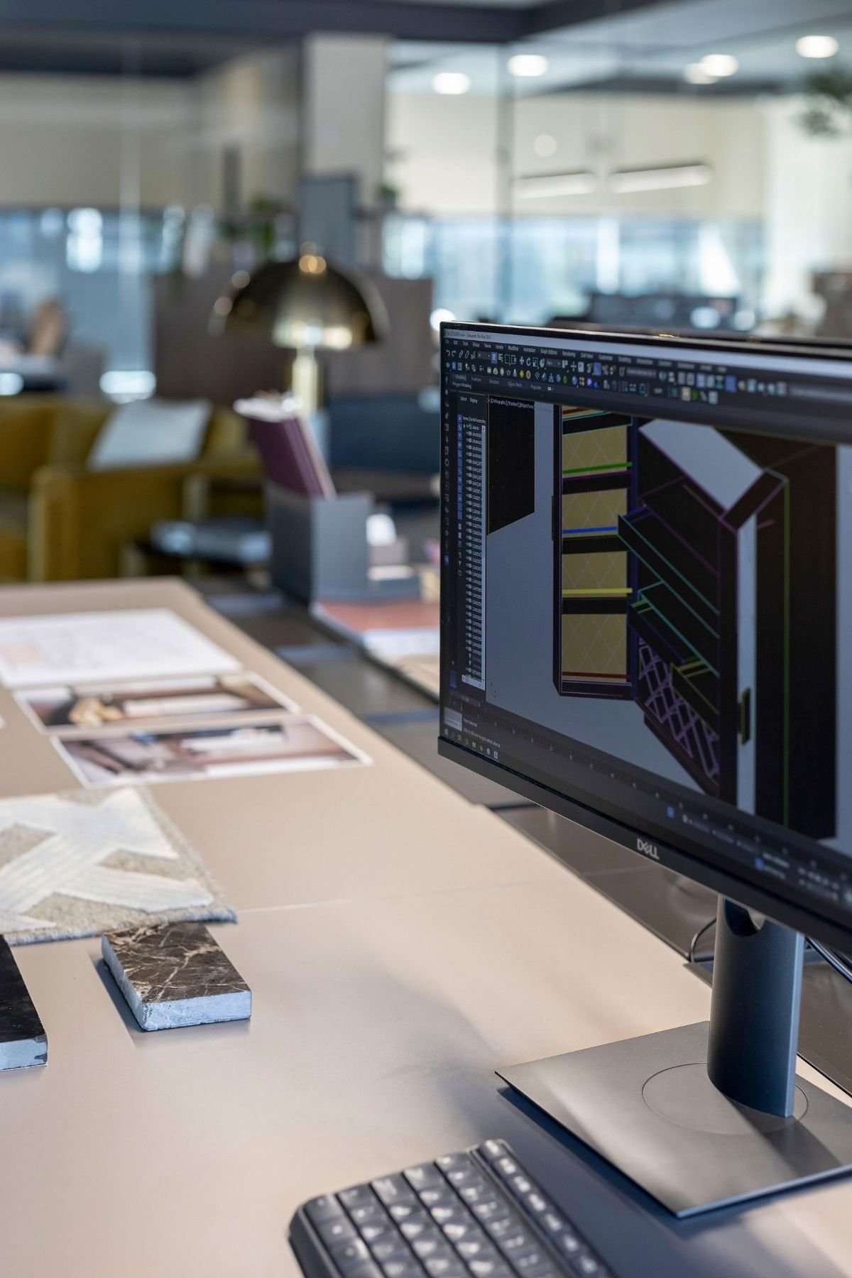 Pormenor de monitor com software de projeto de interiores em cima de secretária de escritório.