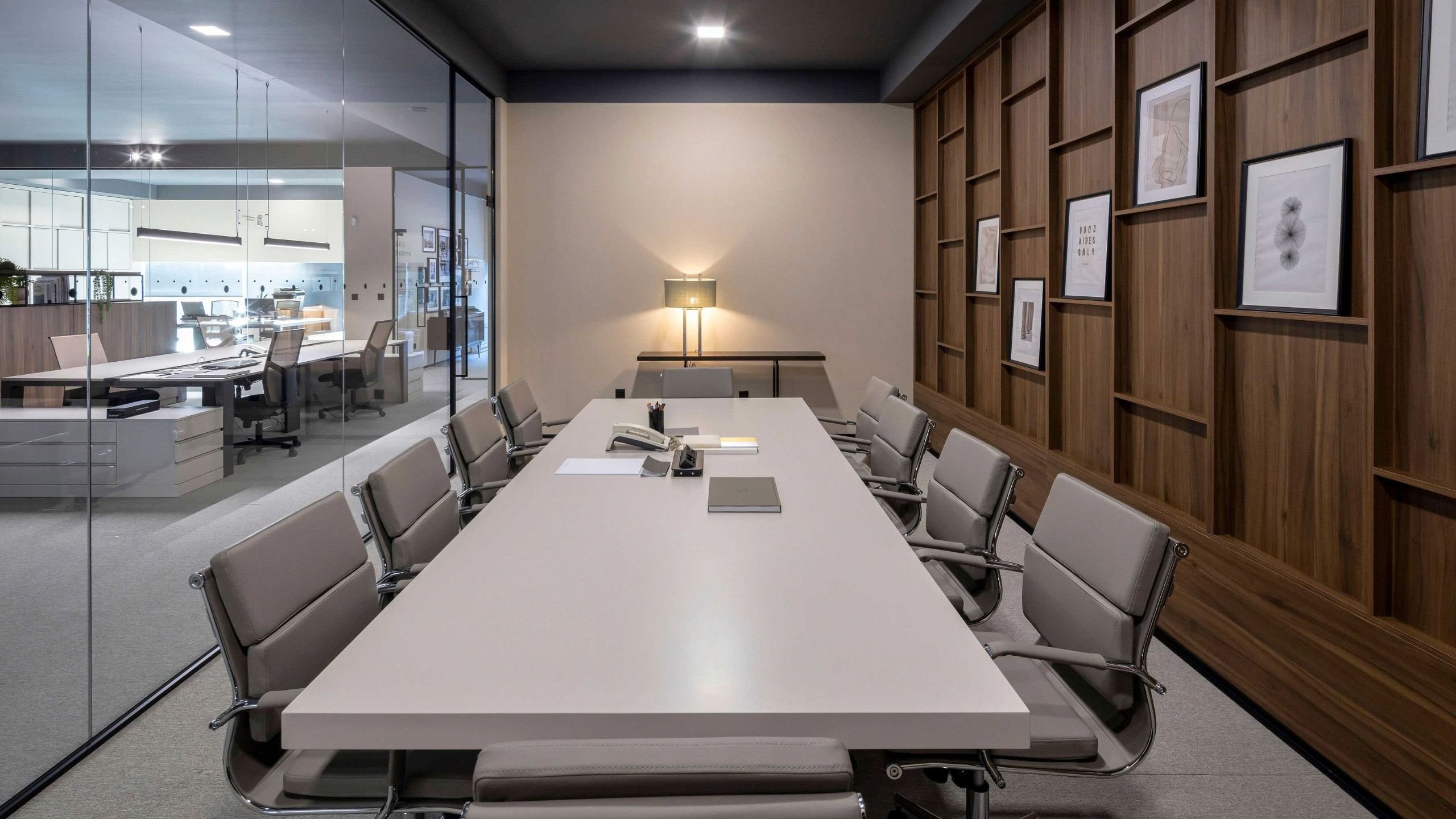Sala de reuniões ampla com mesa de reunião em lacado e cadeira de escritório executiva em pele.