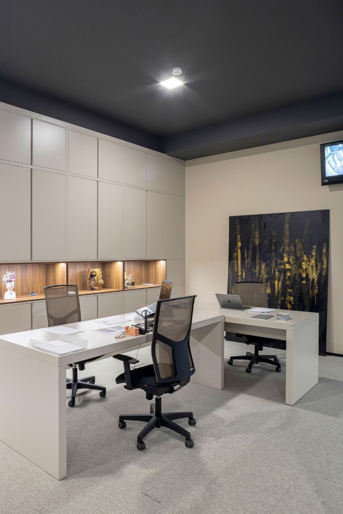 Vista angular do gabinete executivo com secretária de escritório dupla e cadeira de escritório em ambiente de trabalho.