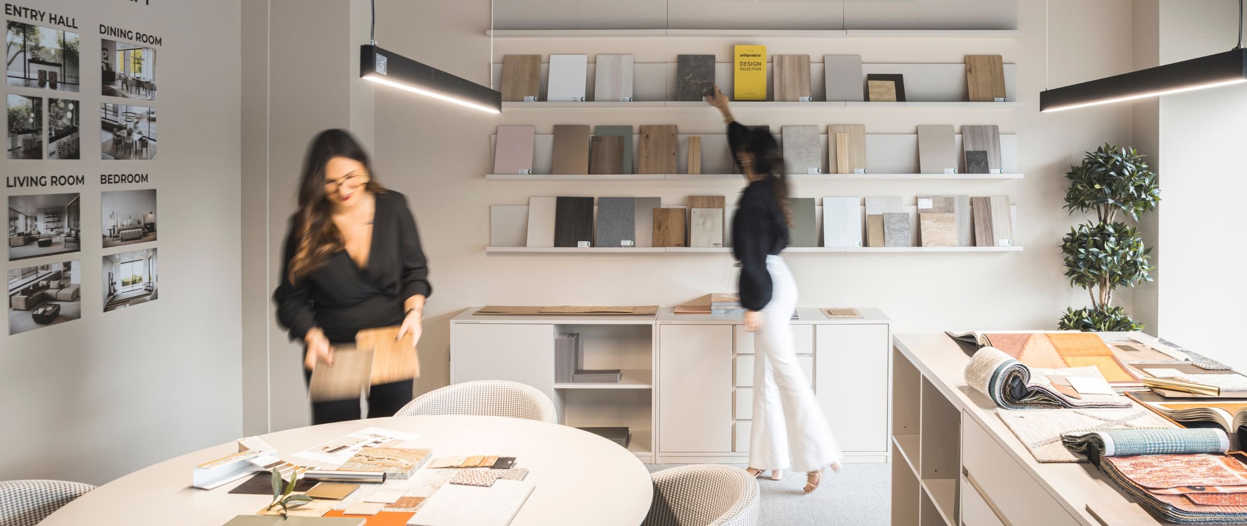 Duas designers num atelier com amostras para serviços de design de interiores e decoração em projetos de moradias de luxo e interior design.