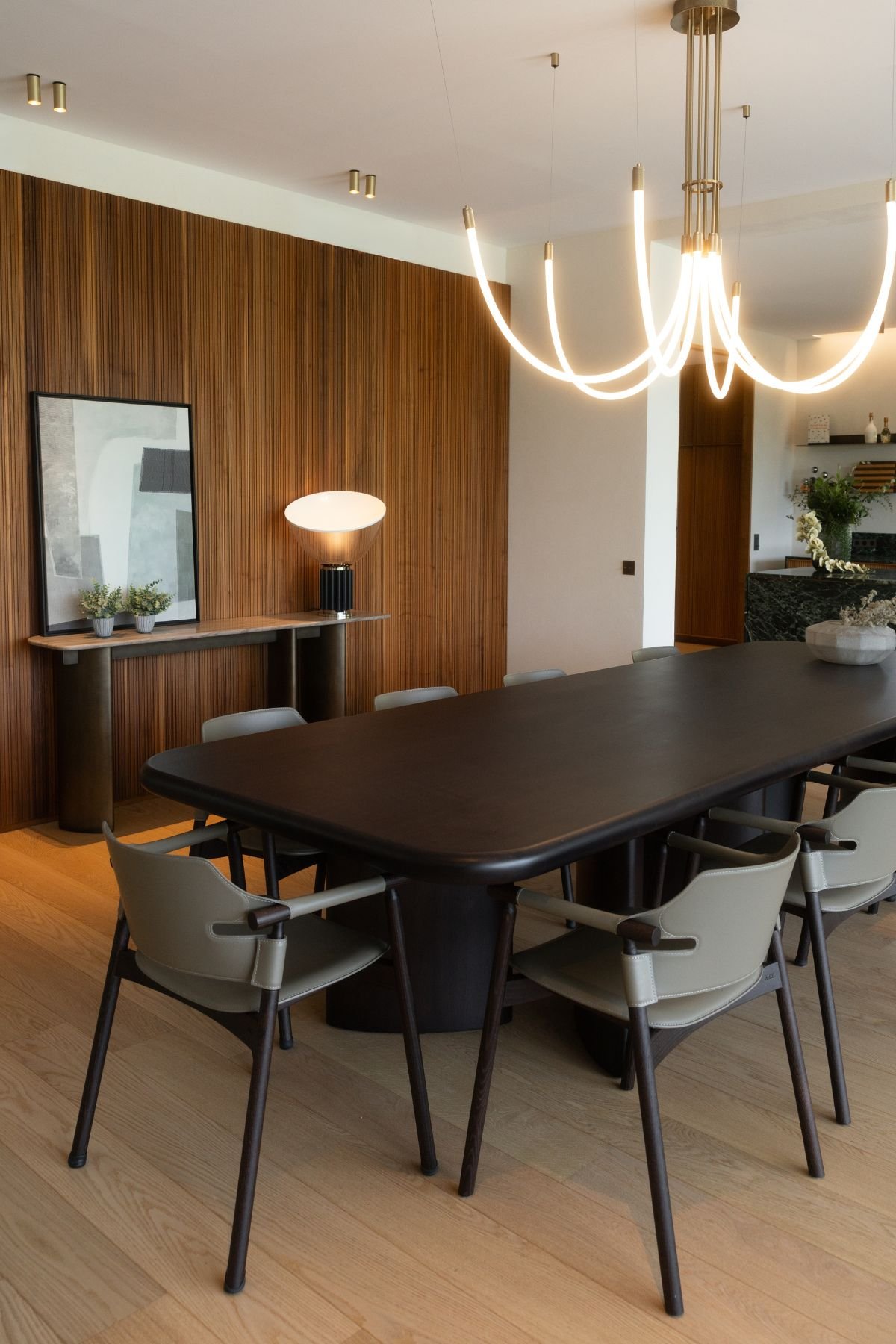 Perspetiva da mesa de sala jantar com cadeira de sala de jantar em pele e iluminação cénica moderna.