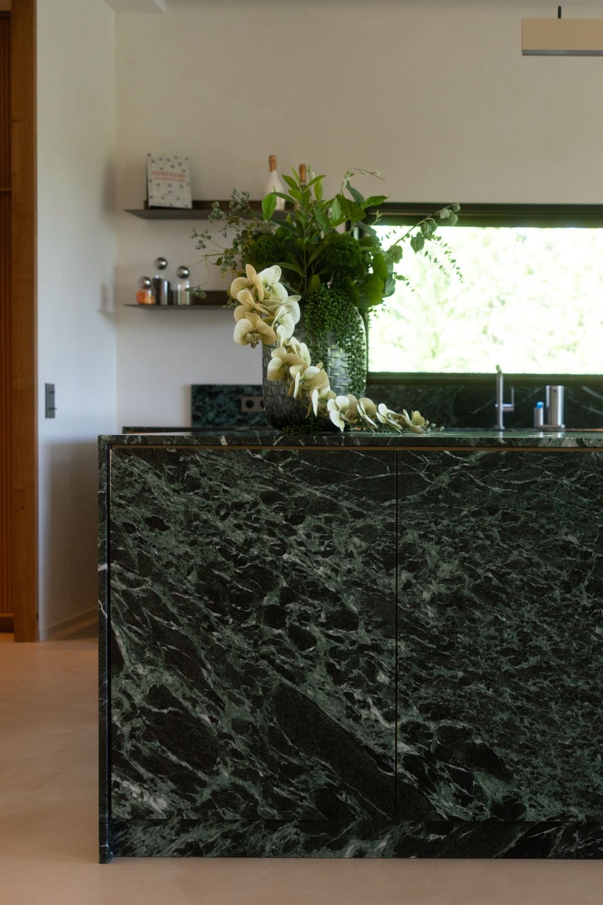 Detalhe do acabamento da ilha em mármore verde Guatemala em cozinhas modernas com ilha.