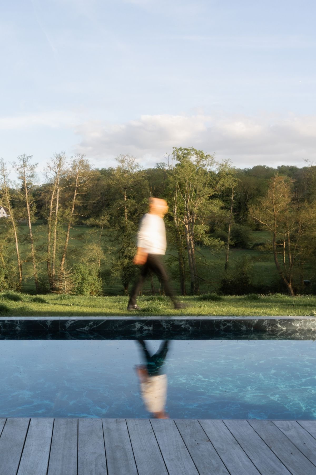 Piscina exterior de linhas modernas com reflexo da paisagem natural envolvente no projeto de arquitetura.