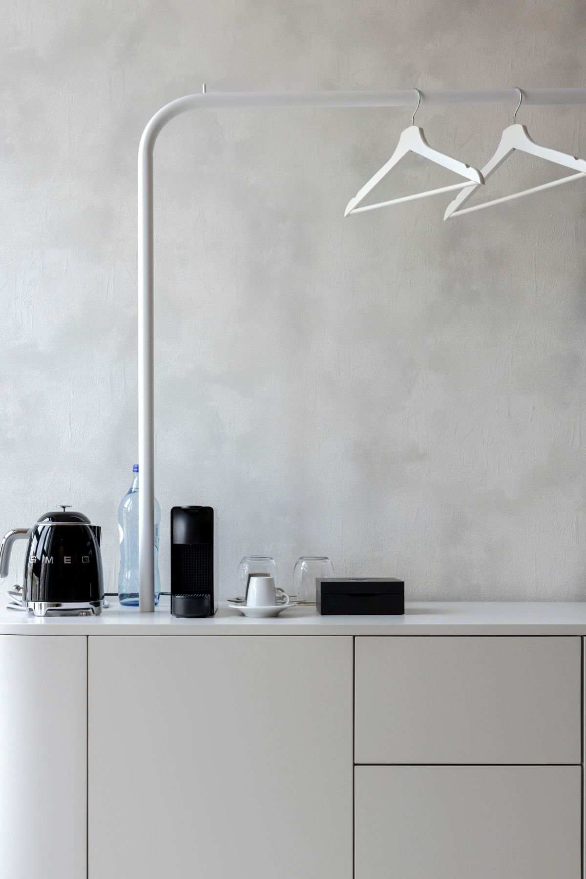Detalhe da cómoda e área de café/chá com cafeteira Smeg, equipada com charmoso suporte superior para cabides.