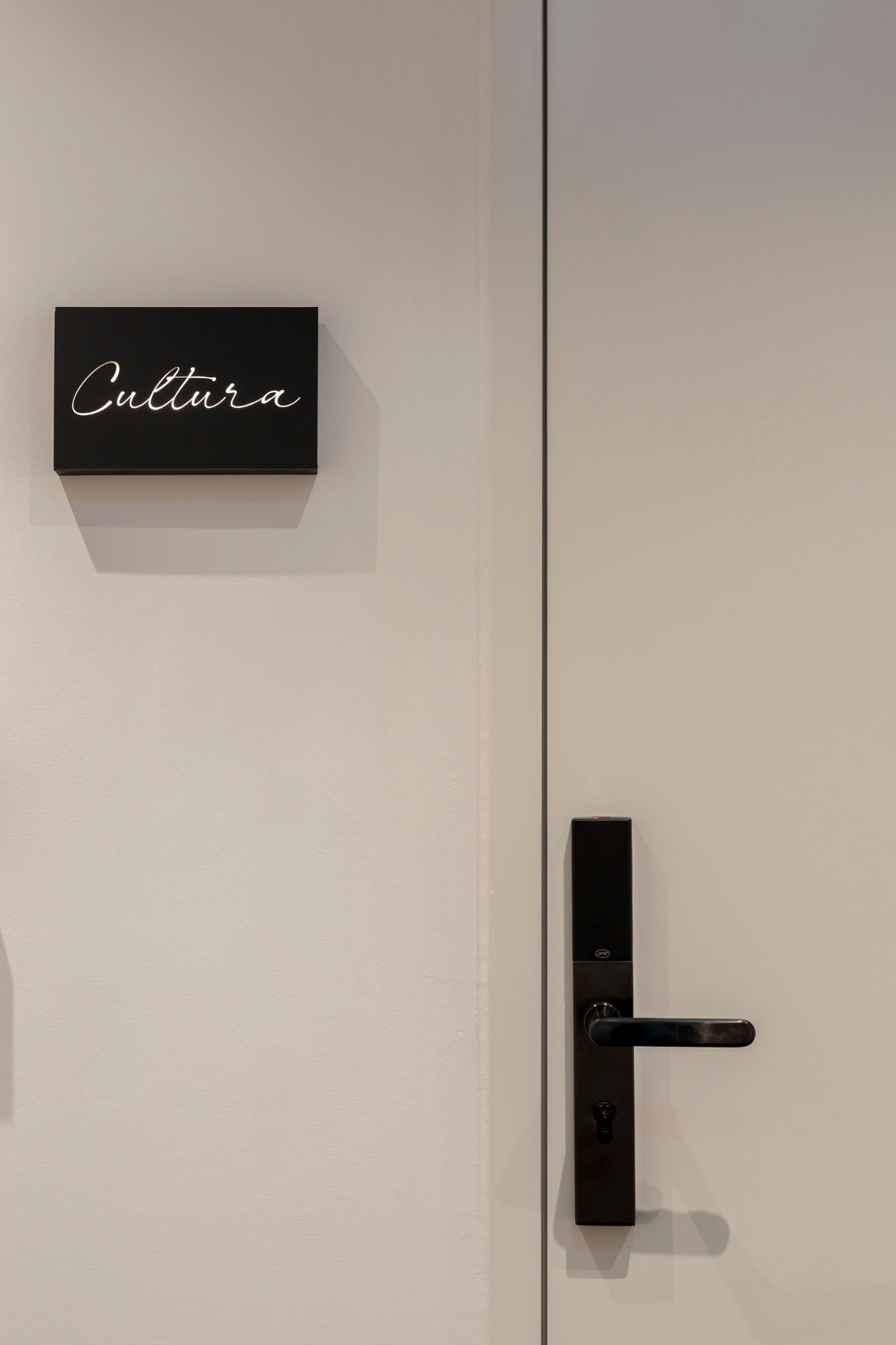 Placa de identificação preta na entrada com a inscrição em caligrafia 