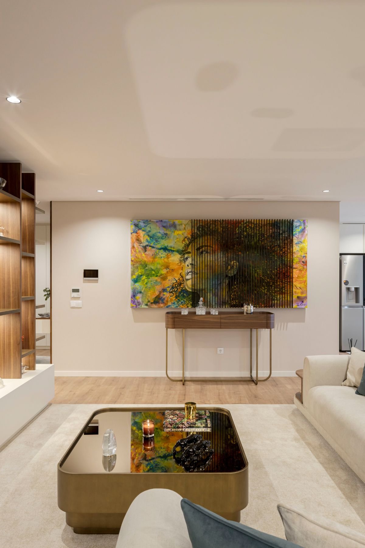 Consola His sob quadro de Pedro Guimarães em sala de estar moderna com mesa de centro e sofá claro.