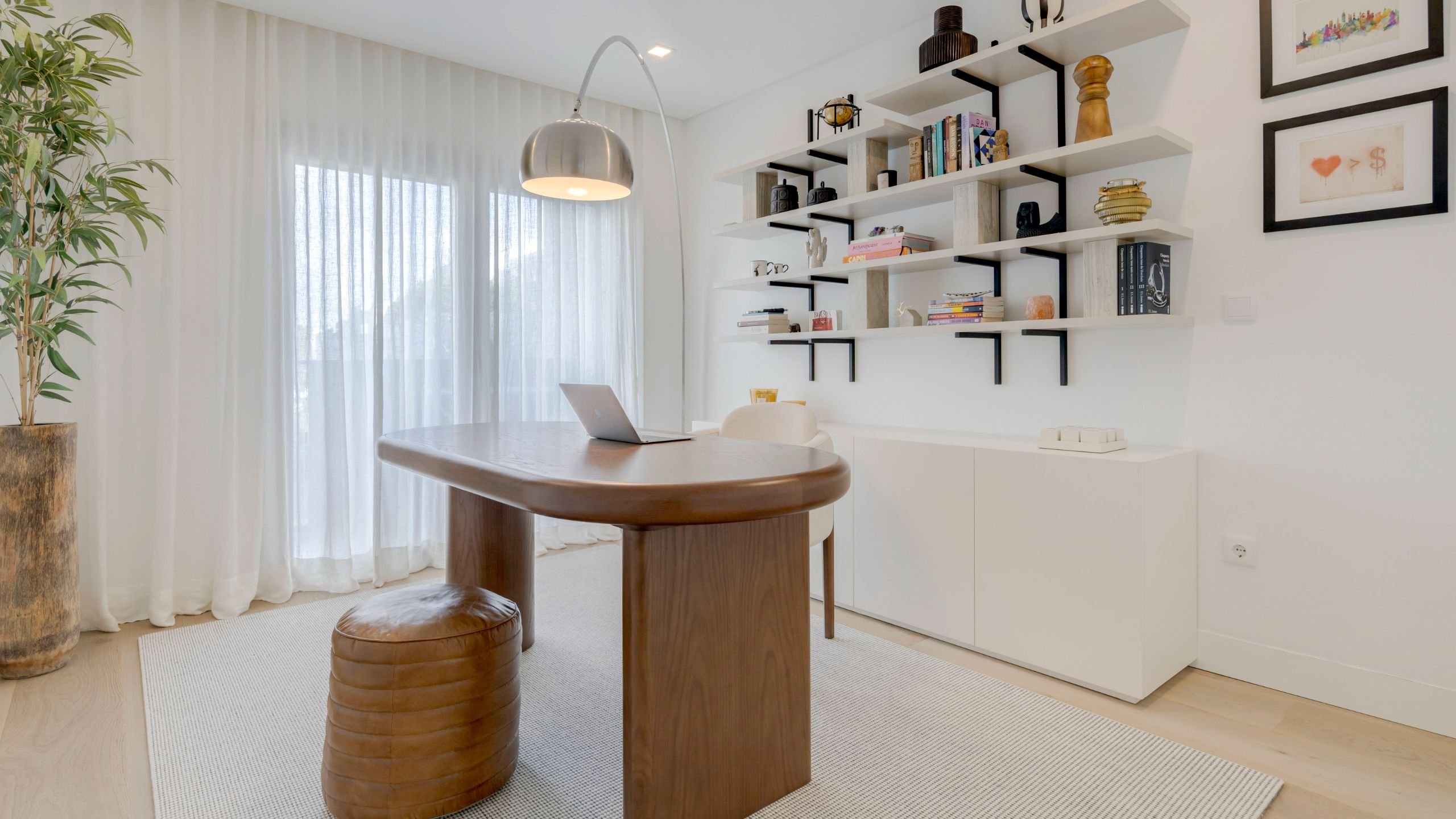 Escritório funcional e acolhedor com mesa Natur em madeira, cadeira His II, estante de parede e móvel de apoio branco.