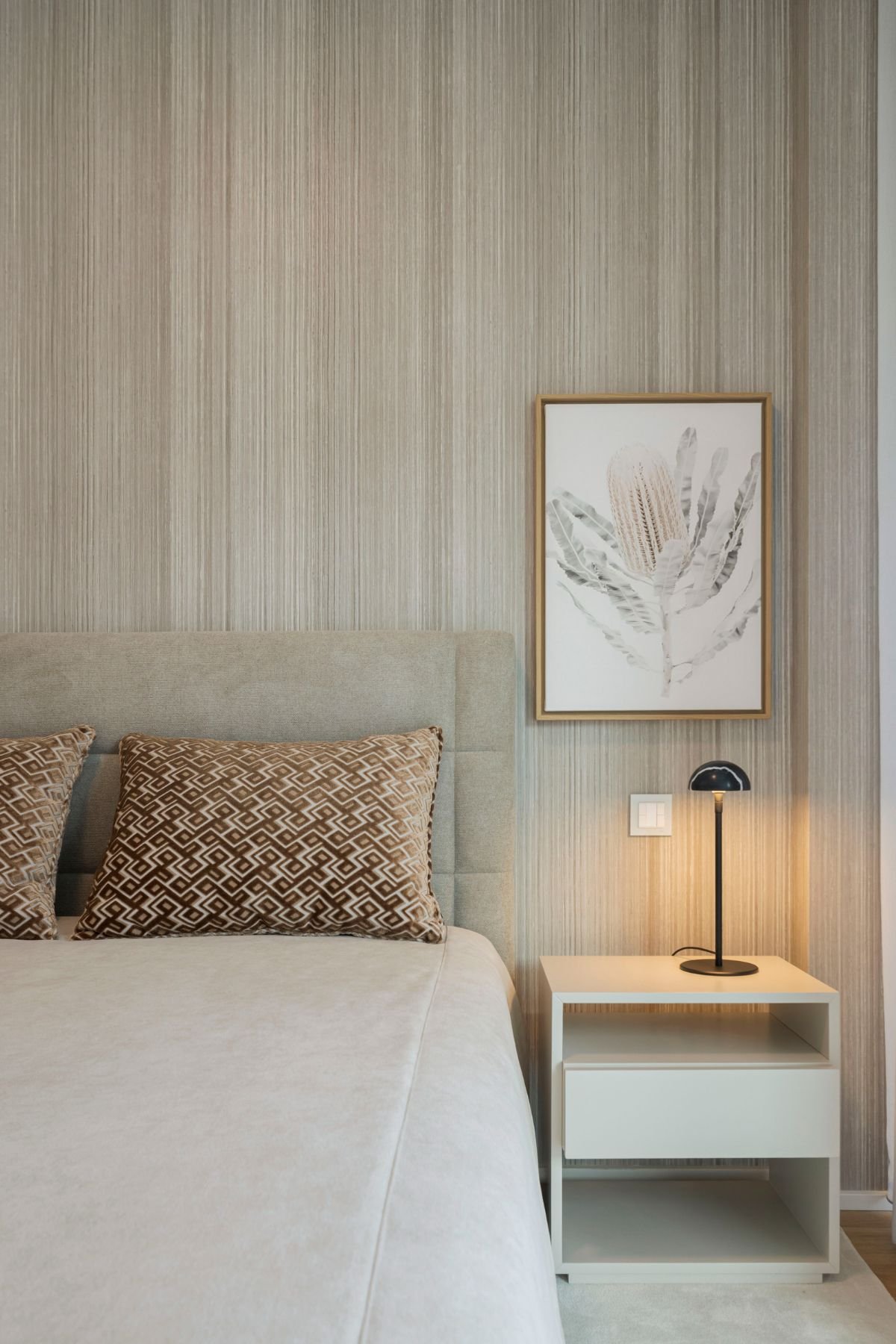 Decoração de quarto de hóspedes com cama de casal, mesa de cabeceira acolhedora e iluminação de mesa elegante.